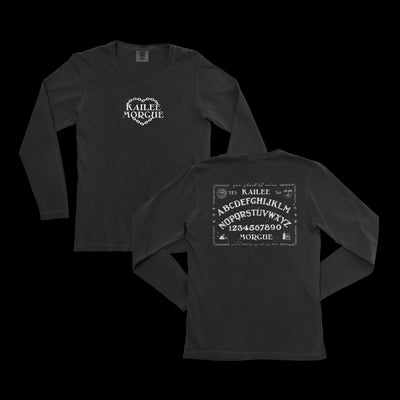 Image of the front and back of a black longsleeve shirt against a transparent background. The front center of the shirt says Kailee Morgue with a chainlink heart in white. The back of the longsleeve features a graphic of a ouija board. The top says Kailee, the bottom says Morgue. In the center of it are the letters of the alphabet, and the numbers 1, 2, 3, 4, 5, 6, 7, 8, 9, and 0. The back graphic is also all in white.